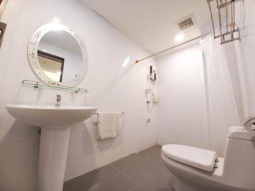 un bagno bianco con lavandino e specchio di CHORLADA LANNA HOTEL a Chiang Mai