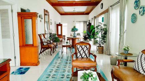 a living room with chairs and tables at Surokarsan 9 House Yogyakarta in Yogyakarta