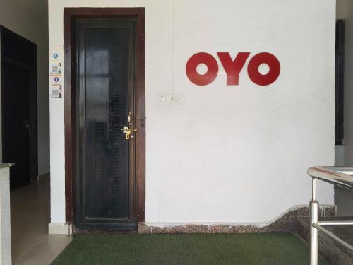 eine Tür mit einem Schild an der Wand in der Unterkunft OYO Vasu Hotel in Alwar