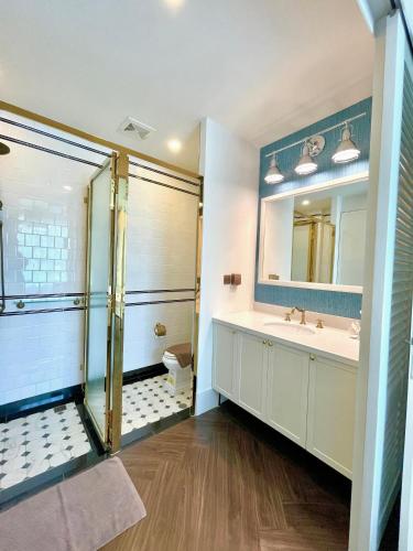 a bathroom with a shower and a sink and a mirror at Grand Florida Beachfront Resort Jomtien Pattaya in Na Jomtien