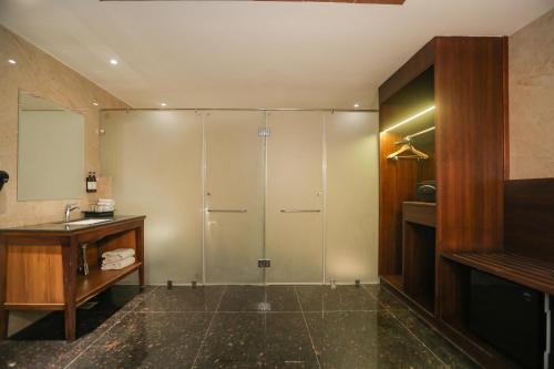 uma casa de banho com um chuveiro e um lavatório. em Regenta Central City Vilas Palace Ambala em Ambāla