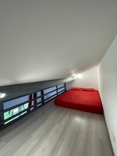 - une chambre avec un lit rouge au milieu d'une pièce dans l'établissement Proche Ajaccio maisonnette indépendante 4 personnes au calme, à Alata