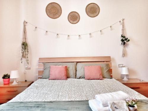 ein Schlafzimmer mit einem Bett mit rosa Kissen in der Unterkunft Baciati dal Sole-Self check-in in San Pellegrino Terme