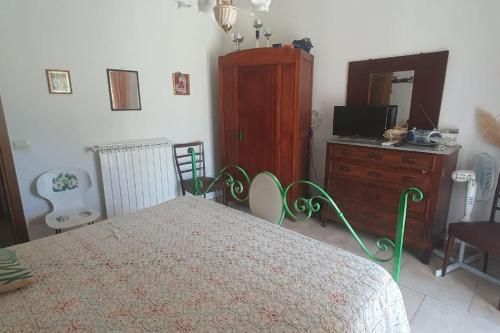 1 dormitorio con 1 cama, vestidor y TV en Residenza Anna, en Montemerano