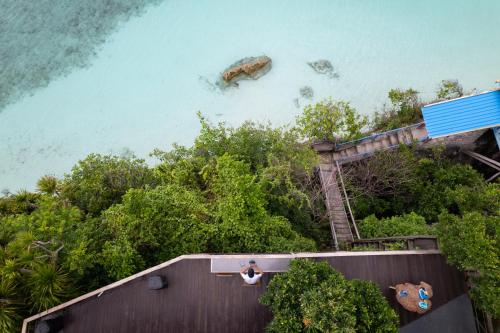 a person sitting on a roof looking at the ocean at Seascapes Bira in Bira