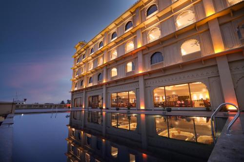 a building with its reflection in a body of water at Regenta Central City Vilas Palace Ambala in Ambāla