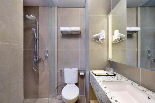 a bathroom with a shower and a toilet and a sink at ibis Yogyakarta International Airport Kulon Progo in Yogyakarta