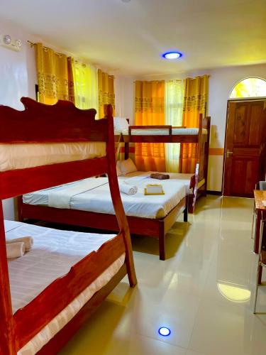 a bedroom with three bunk beds in a room at White Summerville Tourist Inn in Busuanga