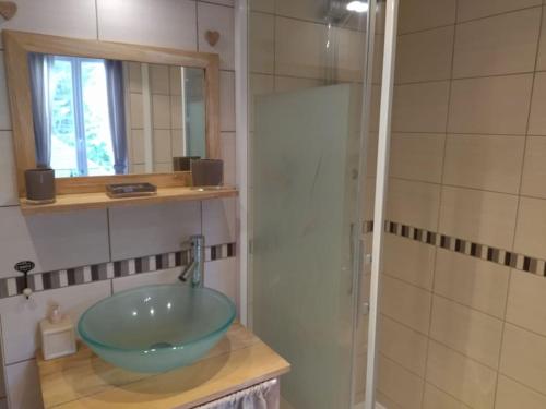 a bathroom with a glass bowl sink and a shower at Appartement chaleureux et cosy in Le Mont-Dore