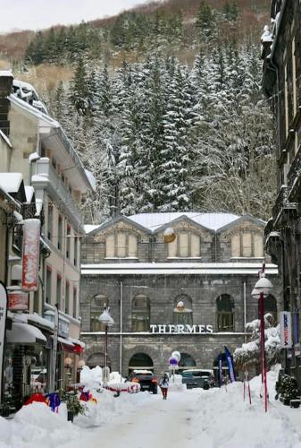 a snow covered street in front of a building at Appartement chaleureux et cosy in Le Mont-Dore
