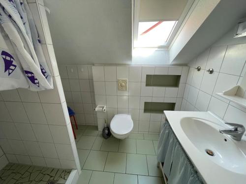 a bathroom with a toilet and a sink and a window at Zuhause mit Aussicht in Neustadt in Holstein
