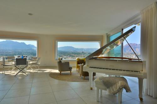 a white piano in a living room with a view at Villa Alegria by NRAS in Albir
