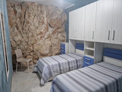 1 Schlafzimmer mit 2 Betten und einer Steinmauer in der Unterkunft SottoCosta in Castro di Lecce