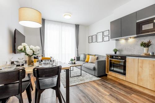 a kitchen and living room with a table and a couch at Apartmán Výhledy Lipno in Lipno nad Vltavou