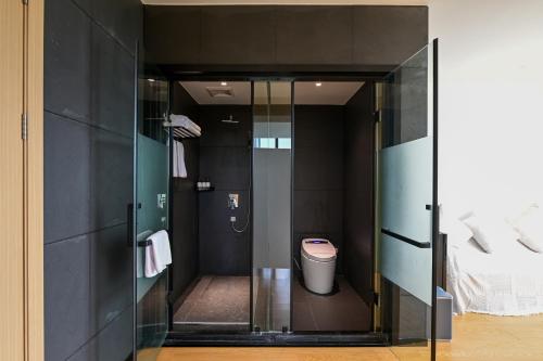 a glass bathroom with a toilet in a room at XMAN Sunrise Peaks Resort--Free Pick-up in Zhangjiajie
