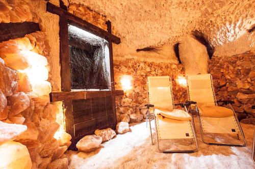 a stone room with two chairs and a fireplace at Rewita Rogowo k Kołobrzegu in Rogowo