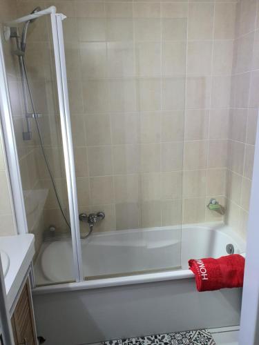 une salle de bain avec une douche et une baignoire avec une serviette rouge dans l'établissement Bienvenue dans le ROUSSILLON, à Argelès-sur-Mer