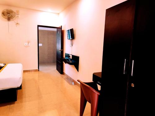 een slaapkamer met een bed en een deur naar een gang bij Yuvraj Galaxy Inn in Mysore