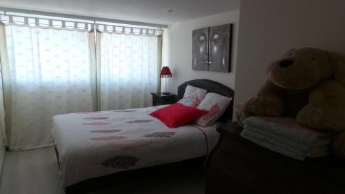 une chambre avec un lit avec un ours en peluche dessus dans l'établissement La petite Logne - logement avec piscine, à Legé