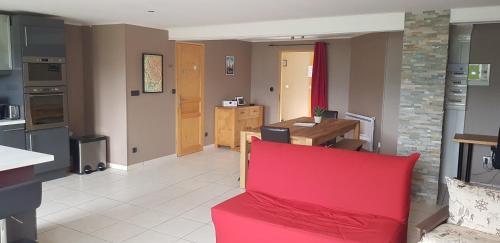 un salon avec un canapé rouge et une cuisine dans l'établissement Les Balcons de l'Eterlou, à Les Deux Alpes