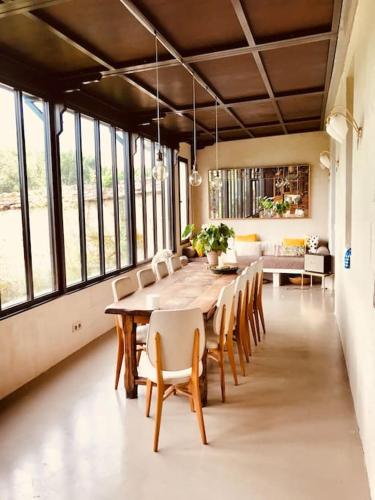 une grande salle à manger avec une table et des chaises dans l'établissement Grande Maison en bord de Seine, 1h 15de Paris, à Muids