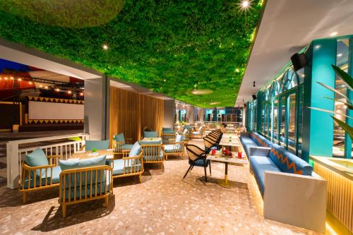 a lobby of a restaurant with a green ceiling at Pentacity Hotel Balikpapan in Balikpapan