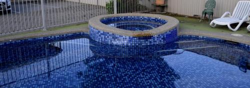 a swimming pool with blue tiles on the floor at Rodney Motor Inn in Mooroopna