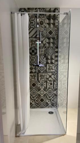 une douche avec des rideaux blancs et un mur carrelé dans l'établissement DUPLEX - VALBONNE VILLAGE, à Valbonne