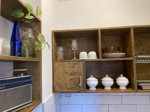 un armario de madera con platos y vasos. en Haifa Vintage Studios en Haifa