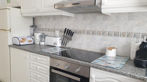 una cucina con armadi bianchi e piano di lavoro di Superior Apartment Casa Vela Albufeira S Rafael beach ad Albufeira