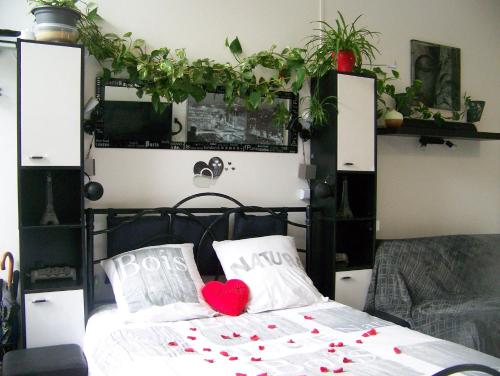 a bed with two pillows with a heart on it at Charmant STUDIO au Calme Tout Confort Dans Château Néo Gothique proche ZENITH COMET ORLEANS Parking Voiture Gratuit WIFI Haut Débit Rue des Montées in Orléans