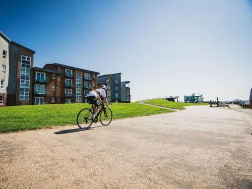 a man riding a bike down a dirt road at Machynys Peninsula Home-Beach/Golf/Cycle- Llanelli in Llanelli