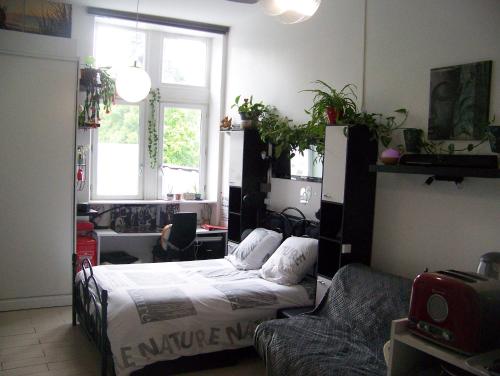 une chambre avec un lit et un canapé dans l'établissement Charmant STUDIO au Calme Tout Confort Dans Château Néo Gothique proche ZENITH COMET ORLEANS Parking Voiture Gratuit WIFI Haut Débit Rue des Montées, à Orléans