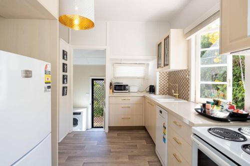 uma cozinha com armários brancos e um forno com placa de fogão em Scarborough Waterfront 2-bedroom Cottage em Scarborough