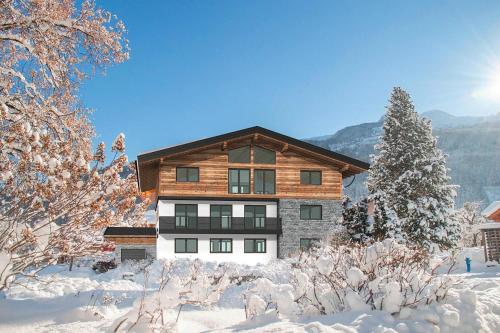 a house in the snow with snow covered trees at Apartment in Bramberg near Cable Car in Bramberg am Wildkogel