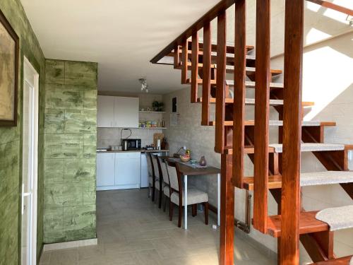 a kitchen and dining room with a wooden spiral staircase at Fruška Gora Guesthouse in Irig