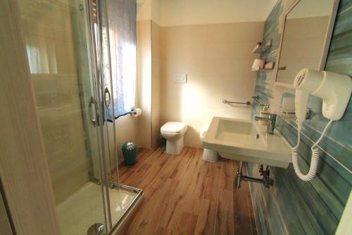 a bathroom with a shower and a sink and a toilet at OLTREMARE in Scalea