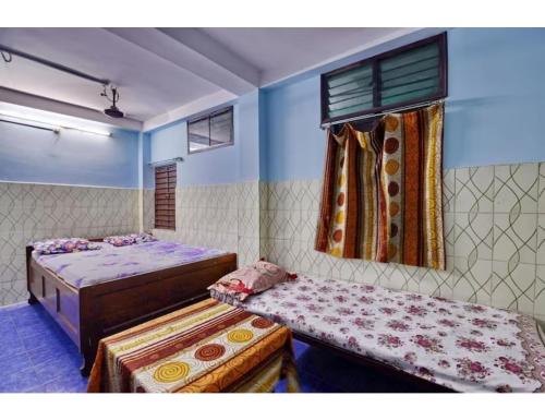 een slaapkamer met 2 bedden en een raam bij Alankar Lodge, Karagpur in Kharagpur