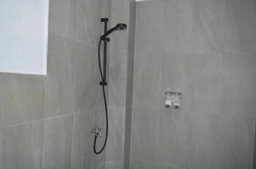 a shower with a shower head in a bathroom at Mahoni Guest House Labuan Bajo in Labuan Bajo