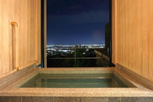 a window with a view of a city at night at 山荘 風の杜 Sanso Kazenomori in Minoo