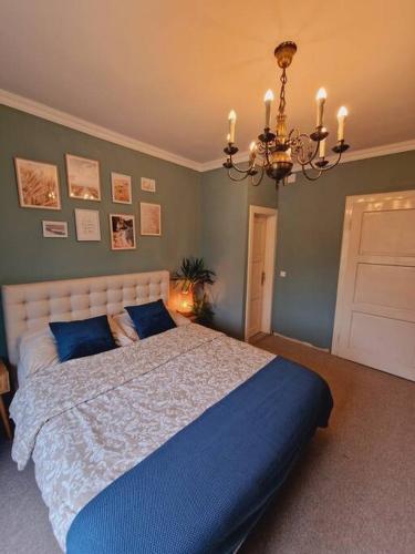 a bedroom with a large bed and a chandelier at Casa Lucia in Knittelfeld