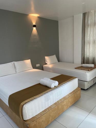 two beds in a hotel room with two bedsvisor at Hotel Lavender Inn in Melaka