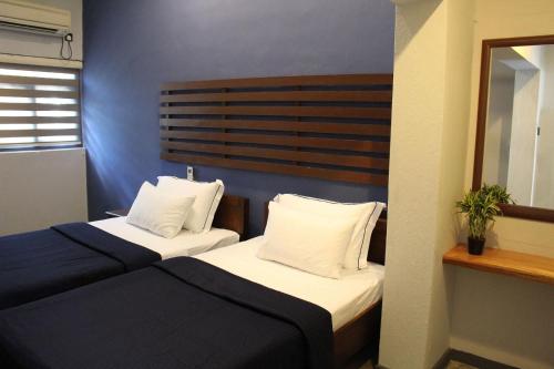een hotelkamer met 2 bedden en een spiegel bij Morning Star Resorts in Negombo