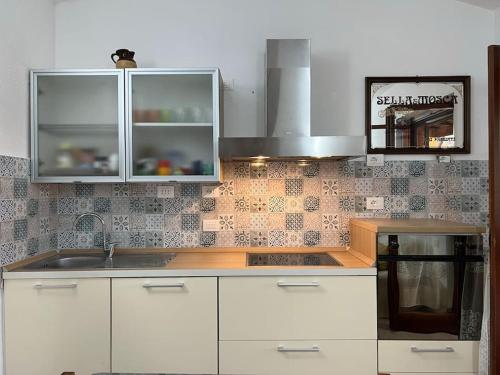 a kitchen with white cabinets and a sink at Casa vacanze a tre minuti a piedi dal mare IUN R1932 in Forte Village