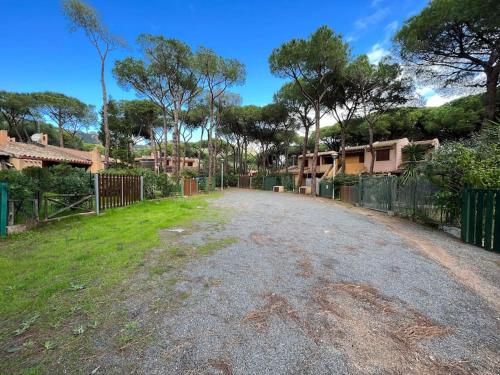 an empty road with a fence and some houses at Casa vacanze a tre minuti a piedi dal mare IUN R1932 in Forte Village