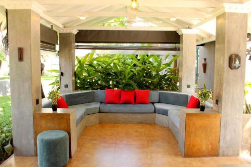 a porch with a blue couch and red pillows at Morning Star Resorts in Negombo