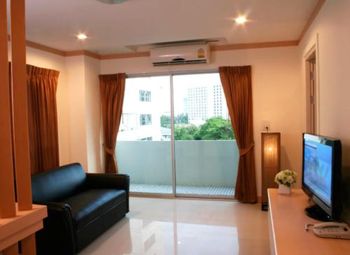 バンコクにあるLove mansionのソファと大きな窓のあるリビングルーム