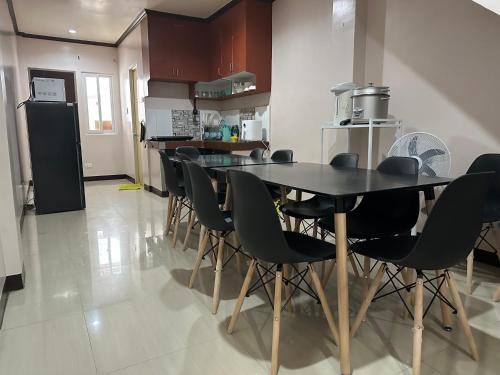 The Townes Davao Townhouses في مدينة دافاو: غرفة طعام مع طاولة وكراسي في مطبخ