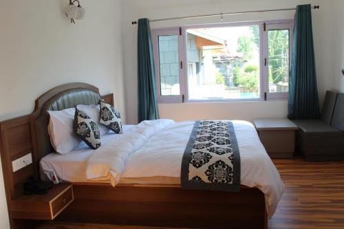 Schlafzimmer mit einem Bett und einem großen Fenster in der Unterkunft Hassanz Enclave in Srinagar