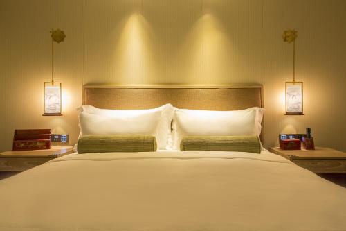 a bedroom with a large white bed with two pillows at LN Hotel Five in Guangzhou